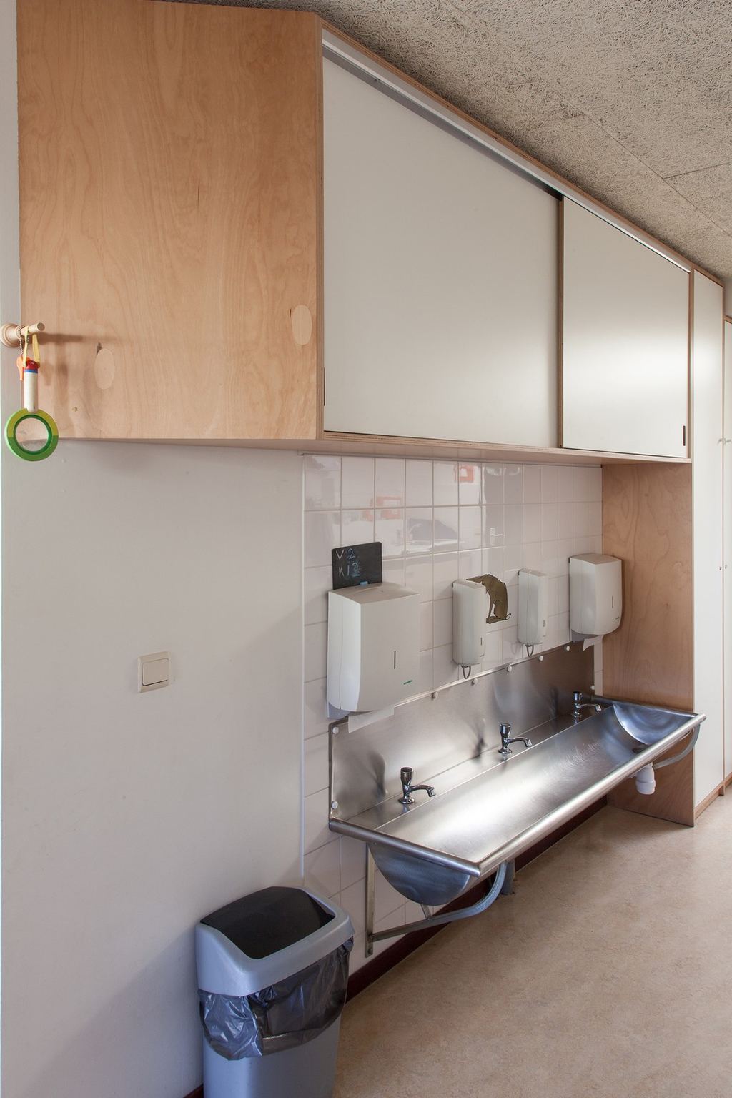 Hoge wandkasten in berken multiplex met schuifdeuren in wit HPL.