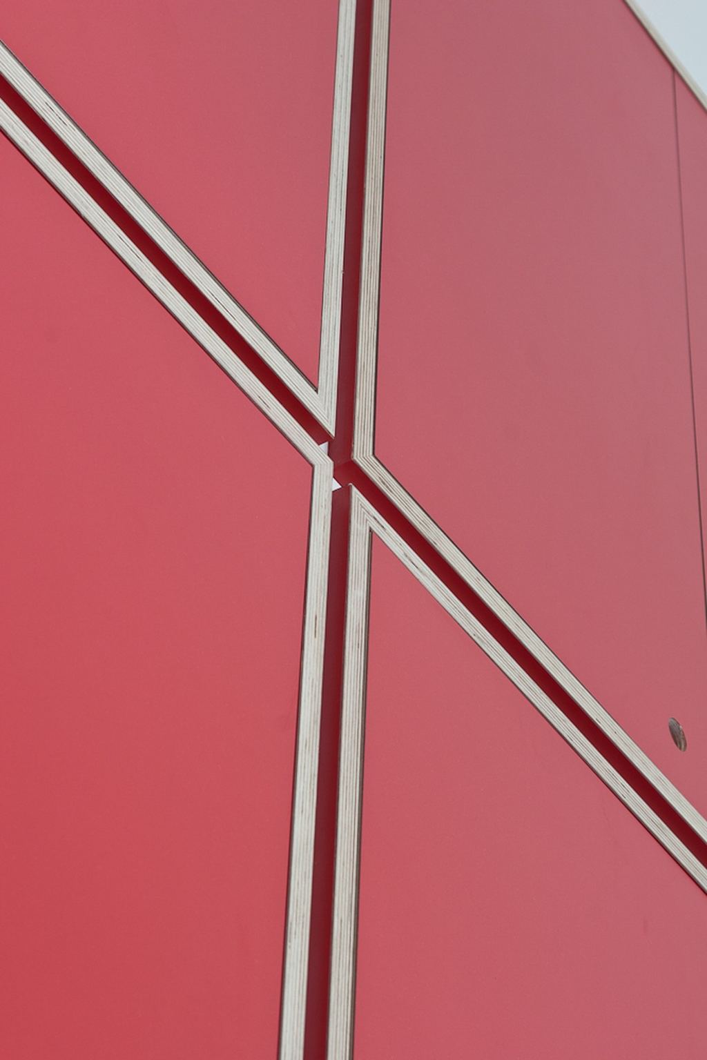 Detail van de diagonale witte lijnen op de rode kastdeuren.