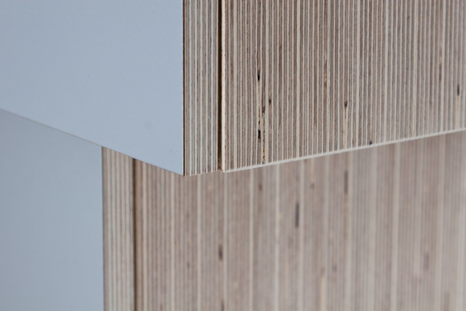 Detail van de hoekverbinding tussen plexwood en een wit front.