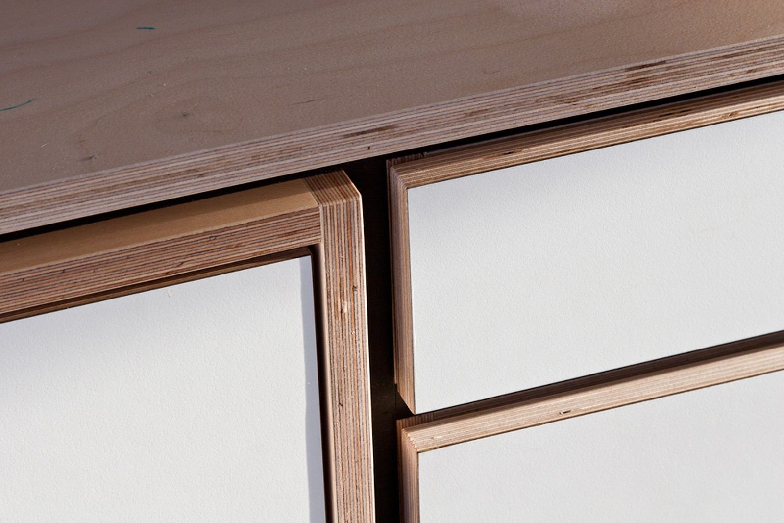 Detail van de hoekverbinding en het witte front van de buffetkast.