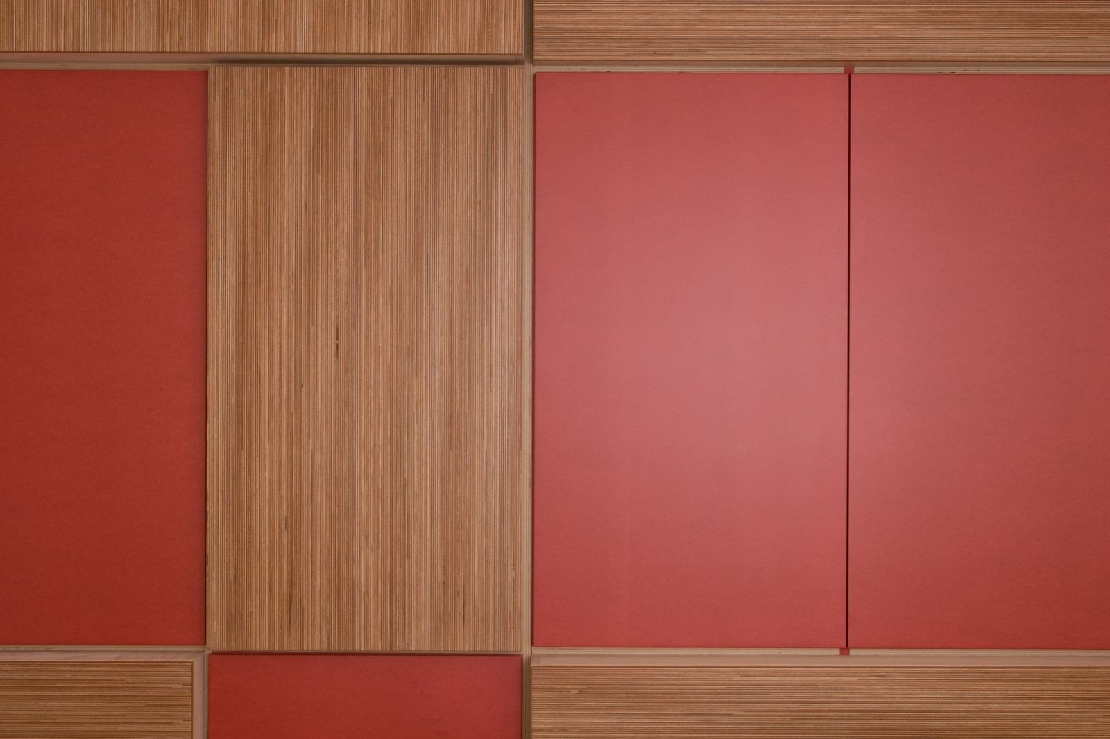 Rode MDF-panelen afgewisseld met gestreepte okumé plexwood vakken.
