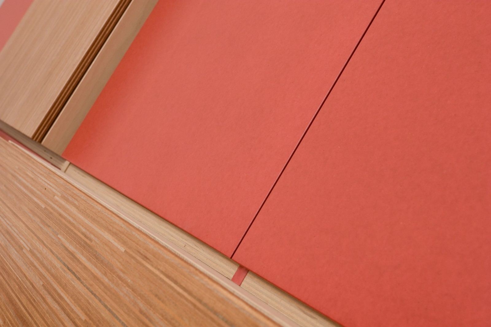 Detail van het door-en-door rode MDF naast plexwood vakken.