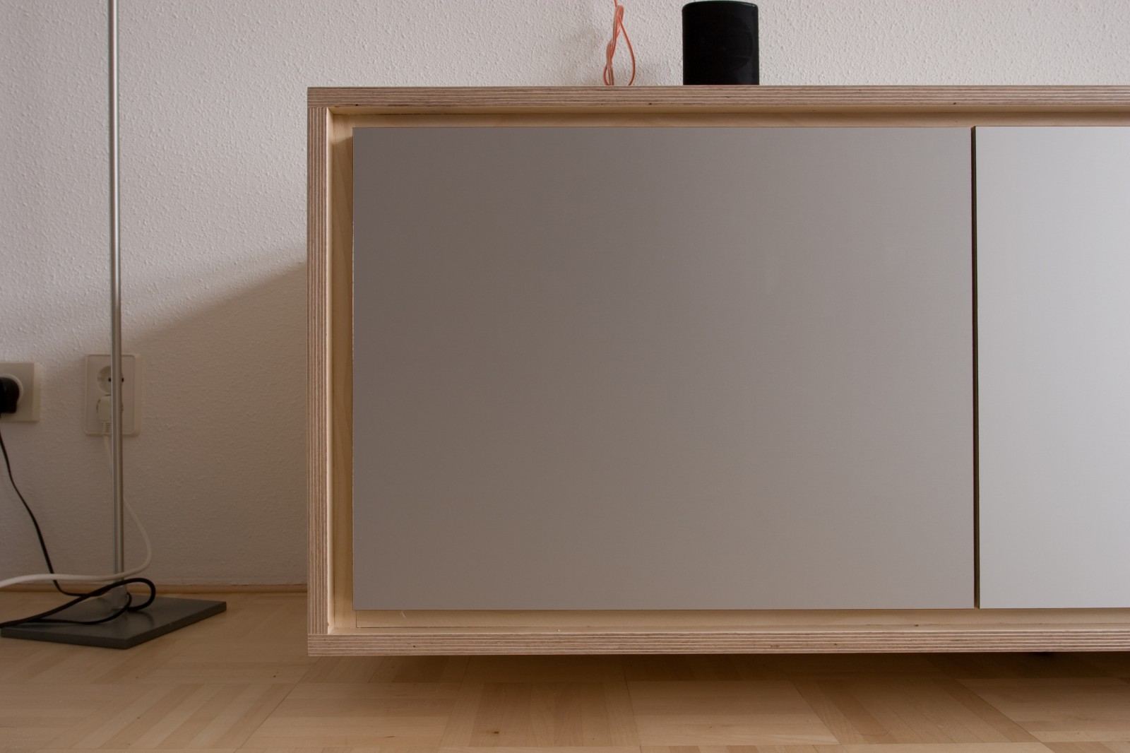 Hoek van het dressoir met een berken kader en grijsbeige front.
