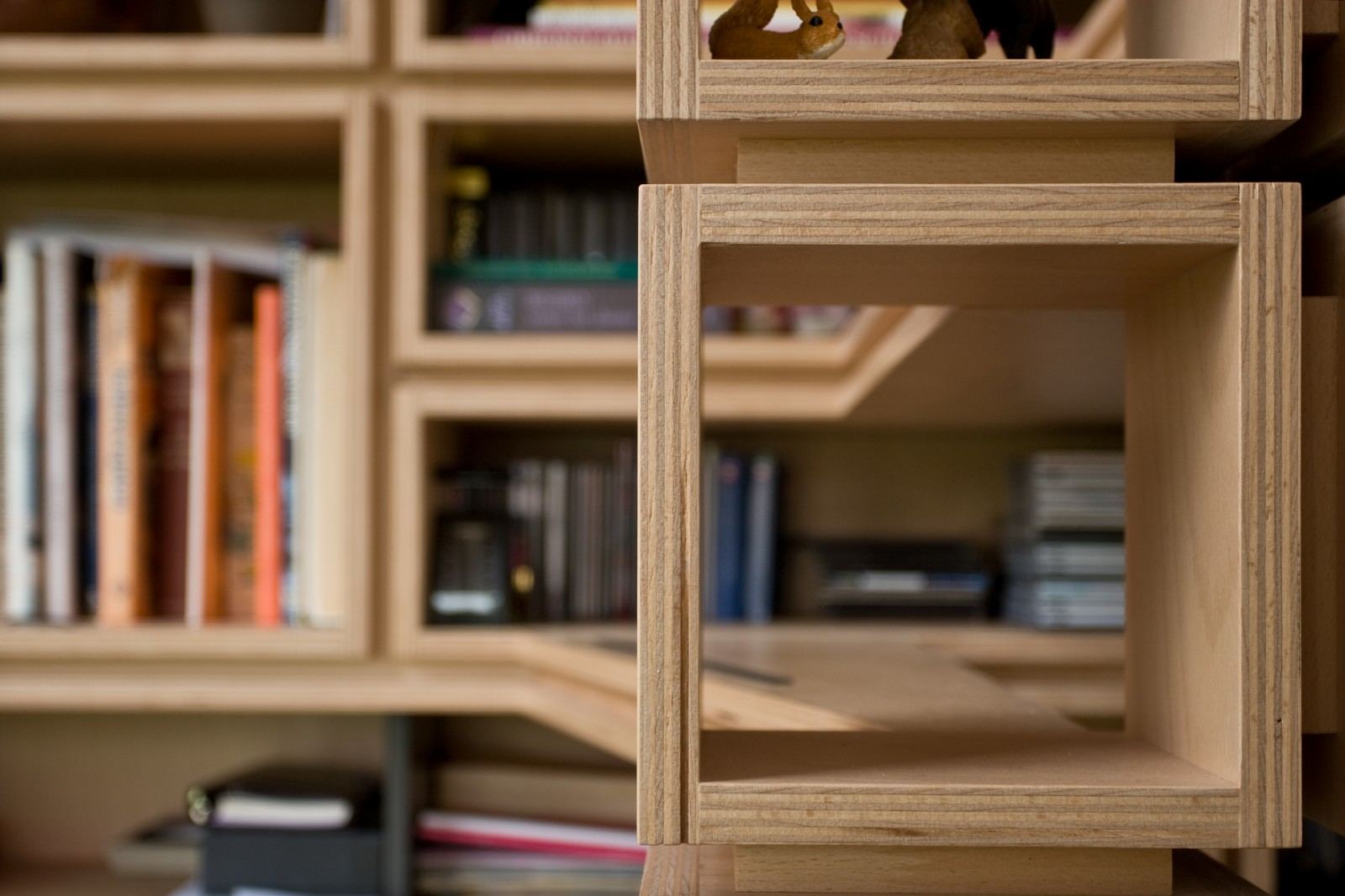 Close-up van een houten kruisverbinding tussen vakken met cd's.