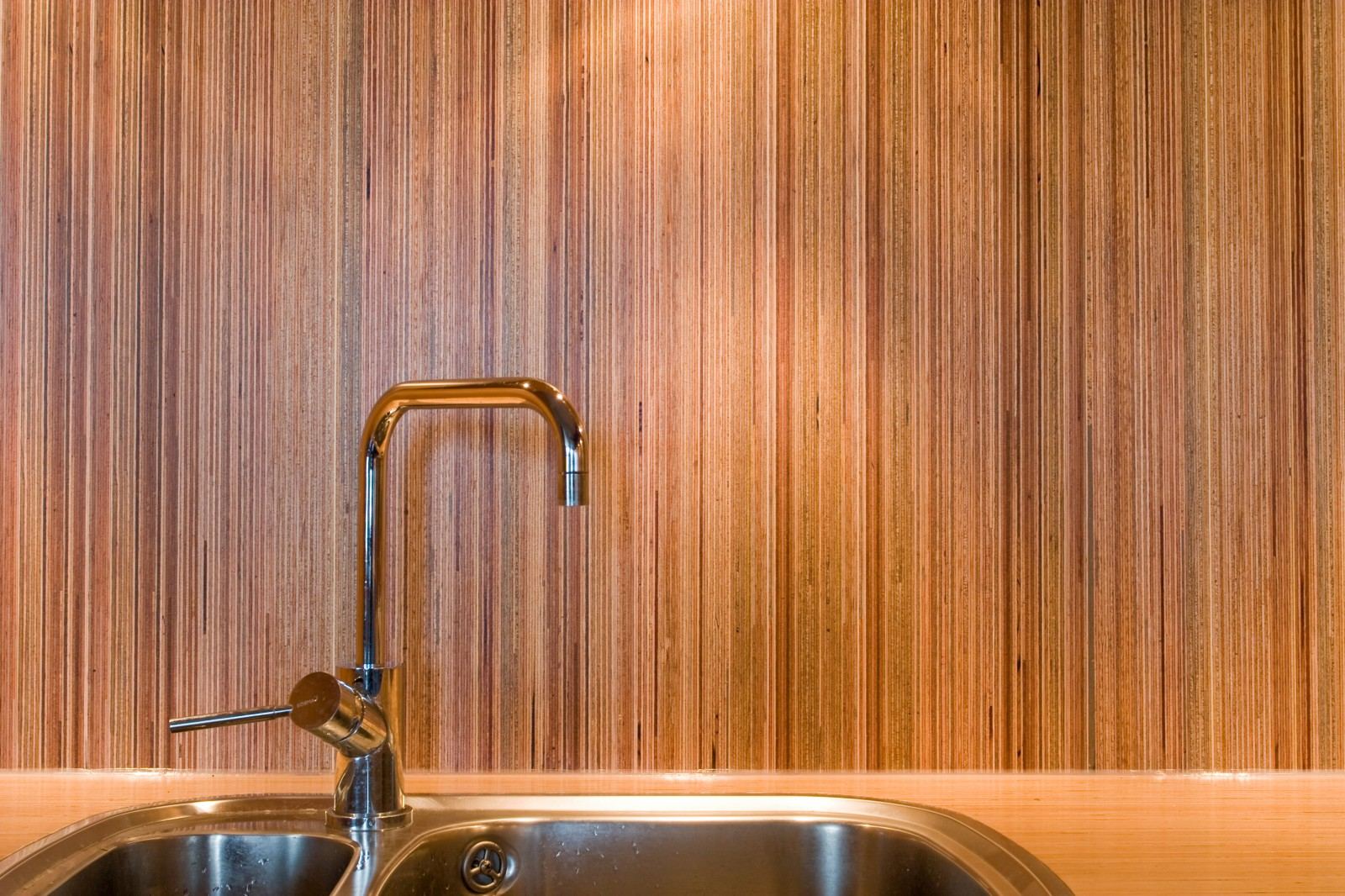 Close-up van de kraan tegen de gestreepte plexwood achterwand.