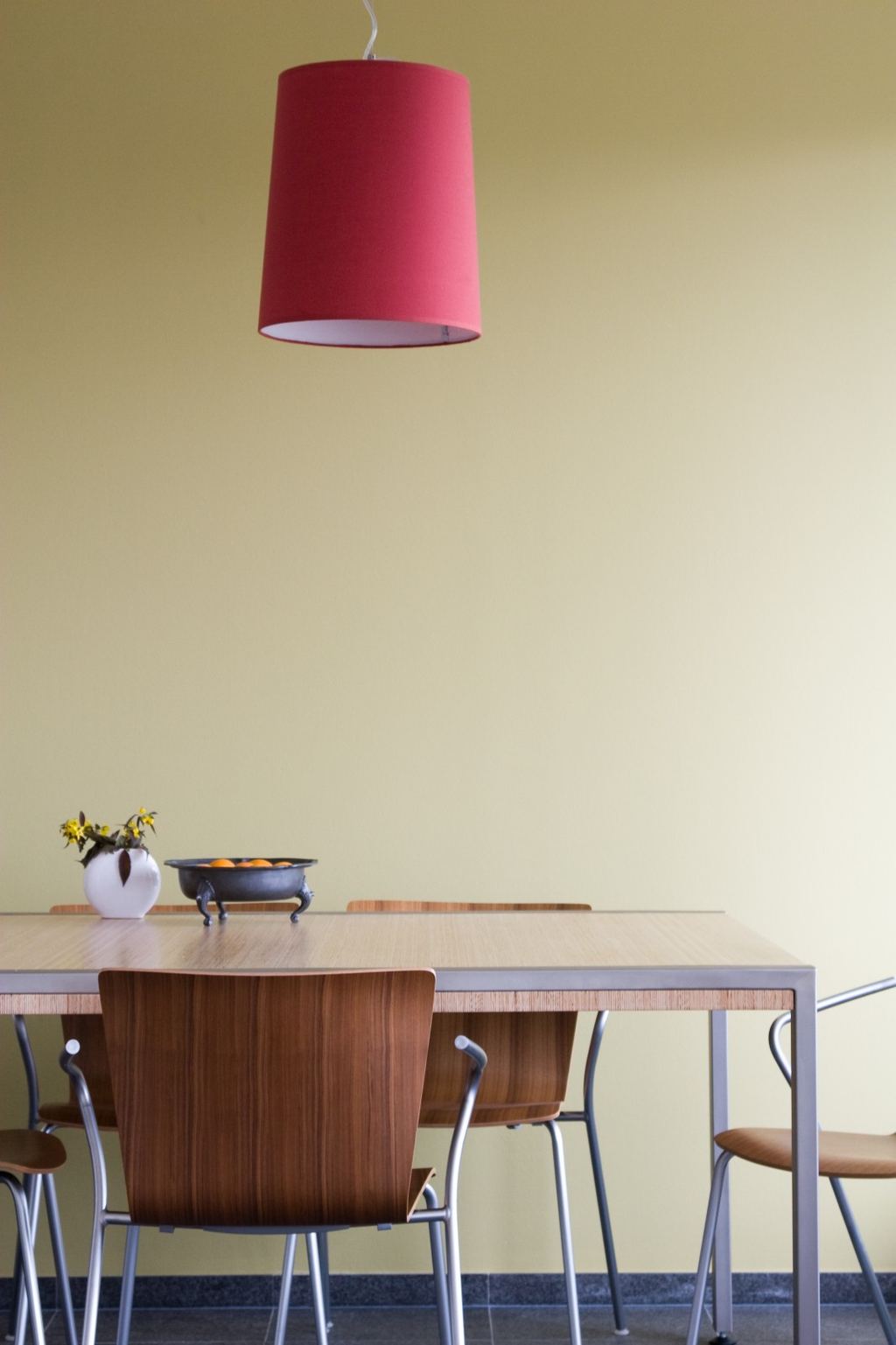 Vierkante eettafel van plexwood grenen op een slank stalen onderstel.
