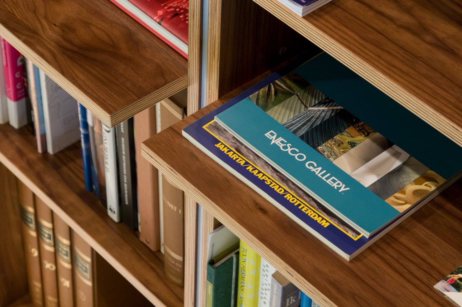 Detail van een uitstekende plank met zichtbare fineerrand in de boekenkast.