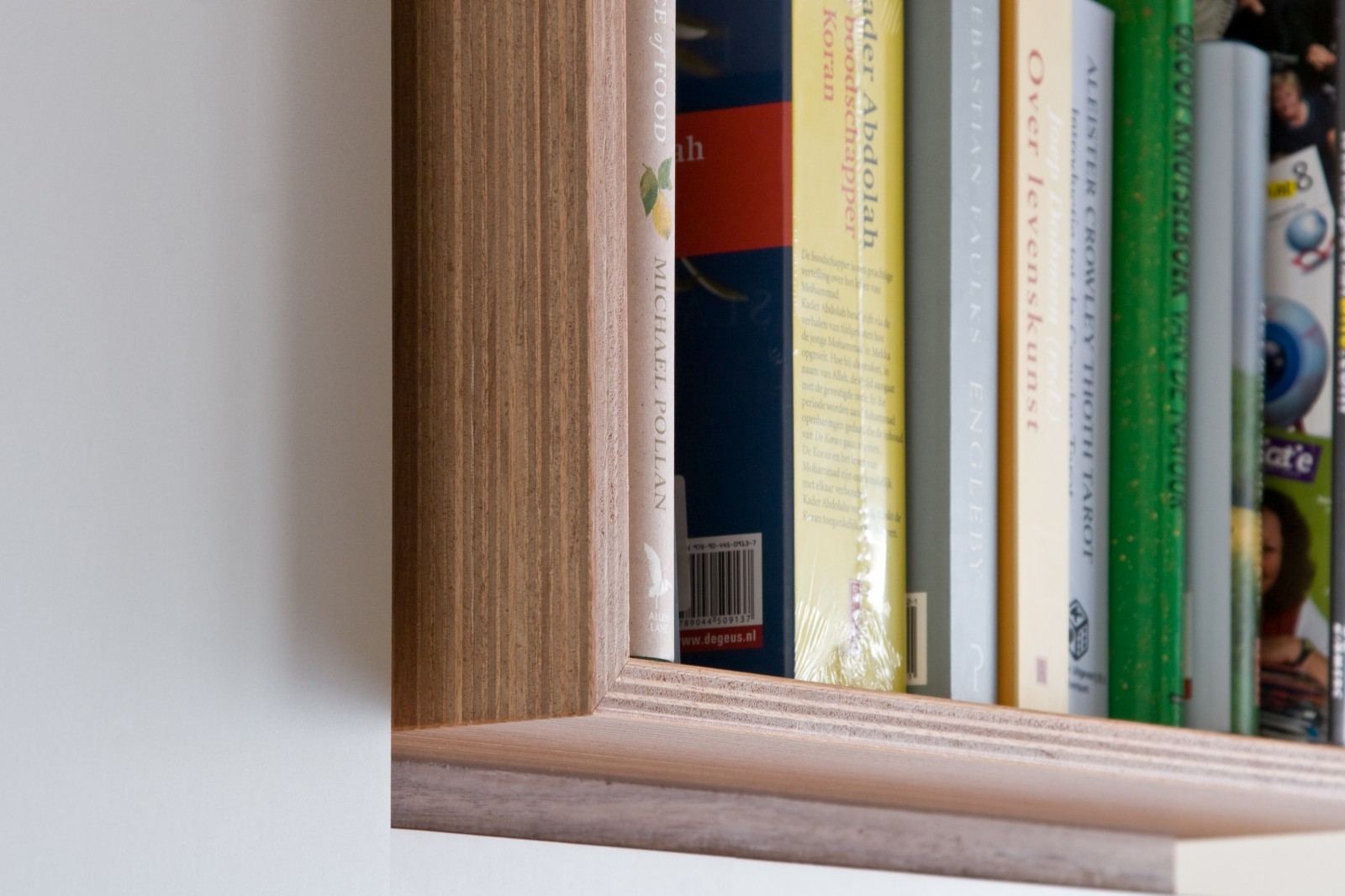 Extreme close-up van boeken op een houten plank in een kastvak.