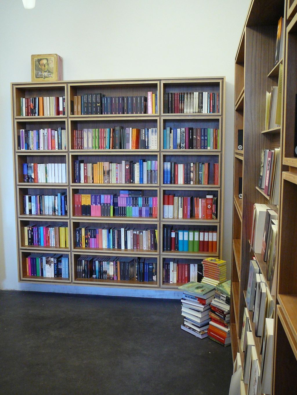 Vierkant boekenrek met losse vakken, met een ingelijste foto bovenop.