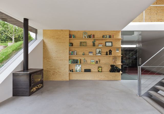 Wandvullend rek van grenen multiplex met boeken en een wijnrek.