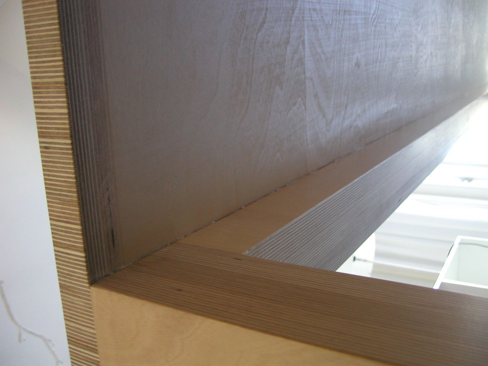 Detail van de gelaagde plexwood rand bij een hoekverbinding.