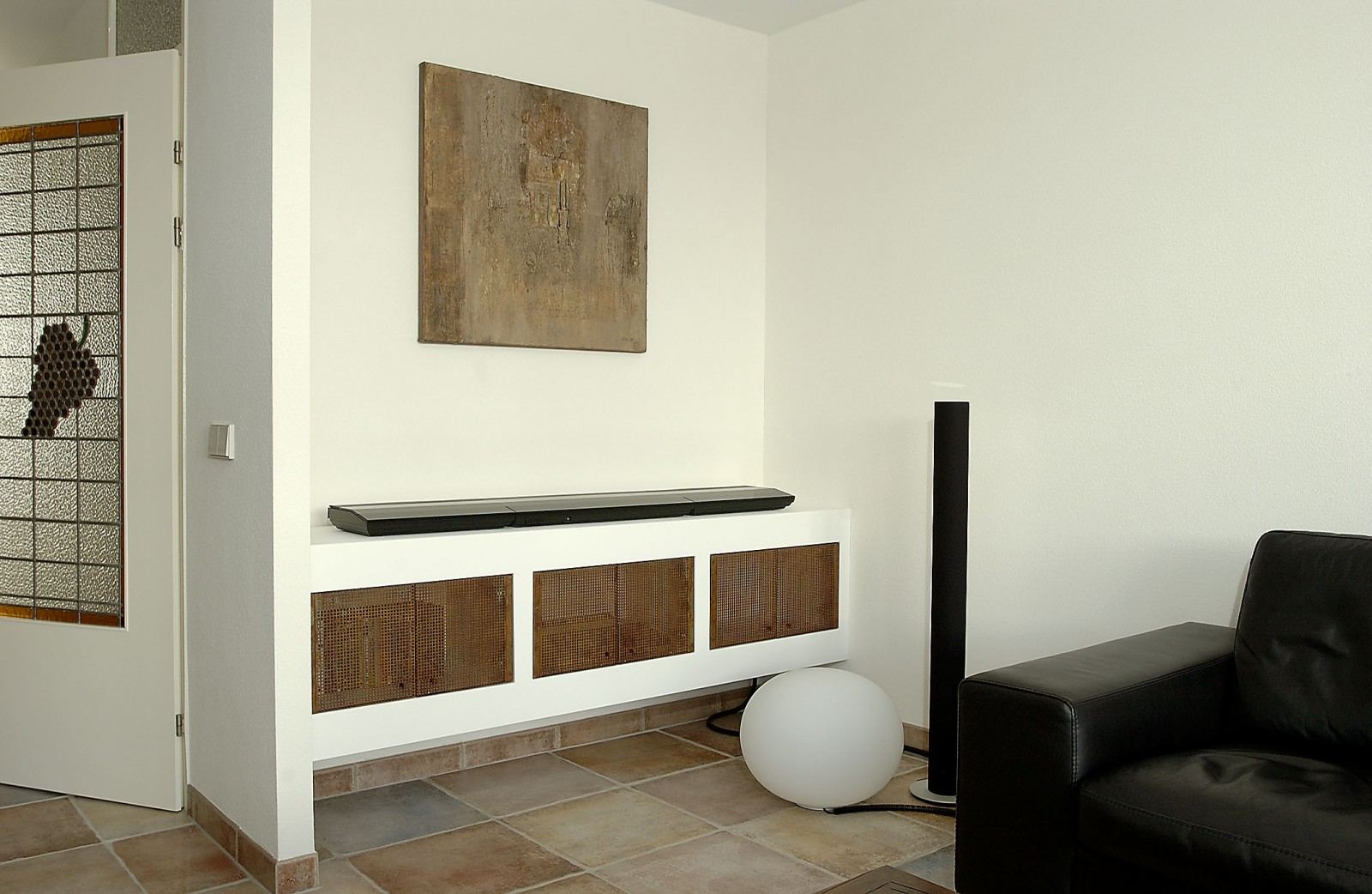 Zwevend wit dressoir met geperforeerde deurtjes, meegepleisterd met de wand.