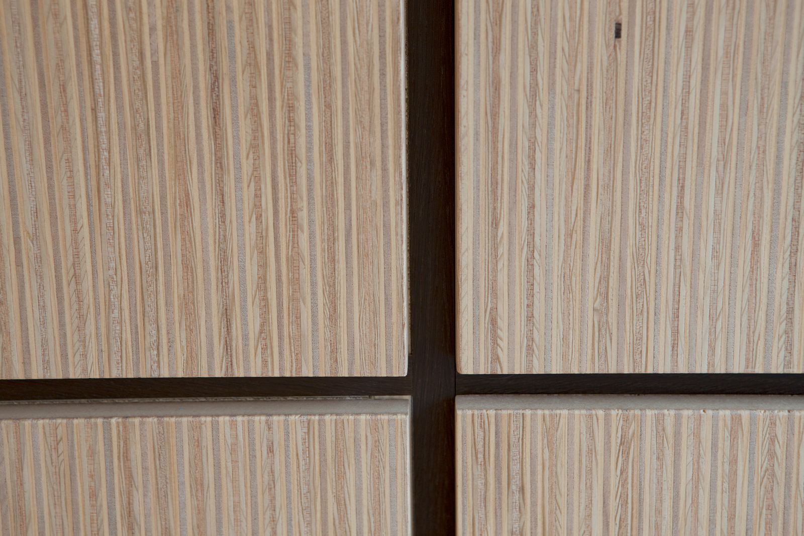 Close-up van de kruisende wengé kaderlijnen tussen de deuren.