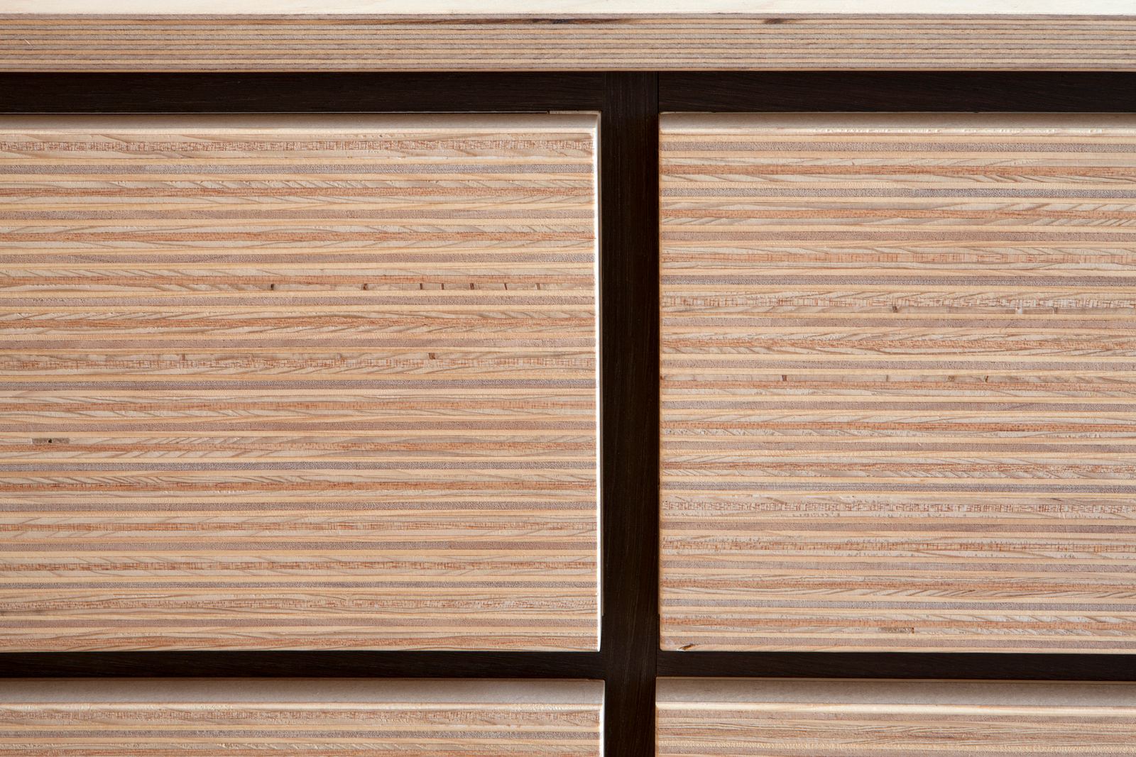 Detail van de plexwood ladefronten met wengé lijnen ertussen.