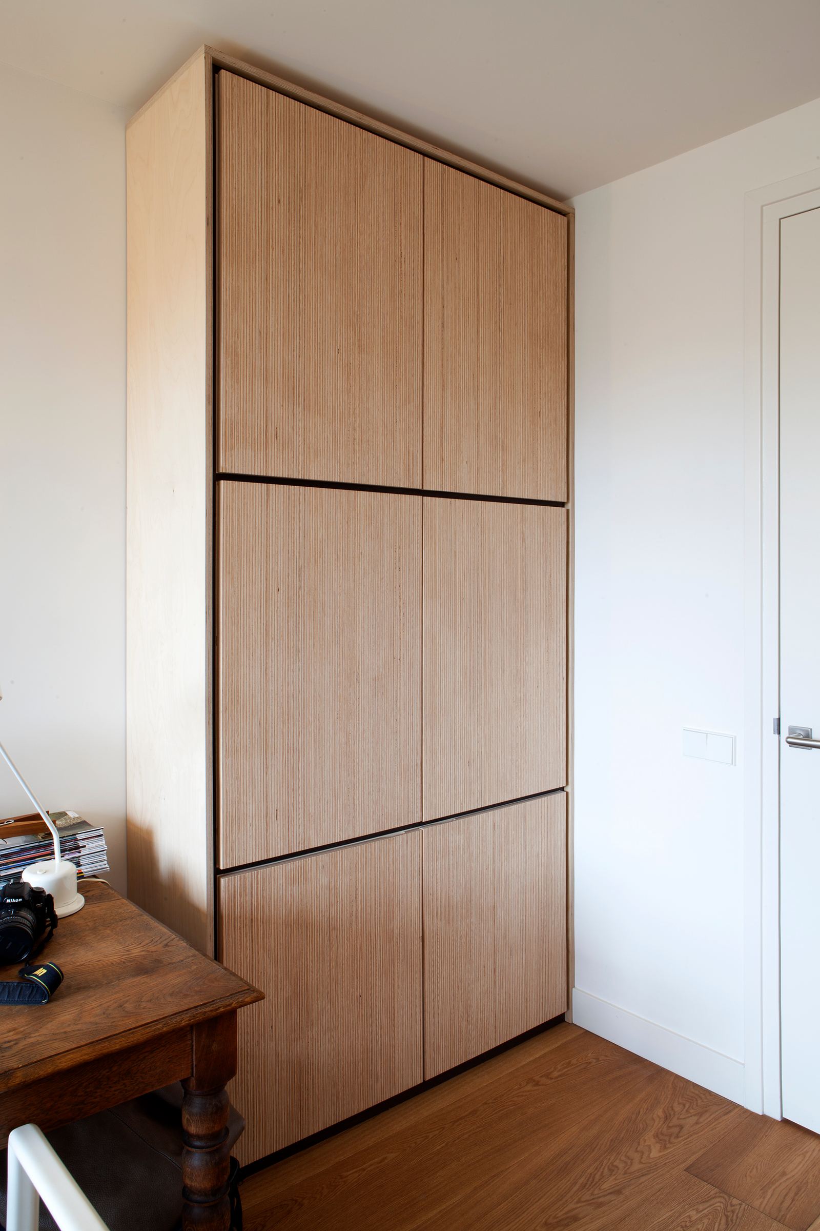 Kast met plexwood berken fronten en dunne wengé stroken tussen de vakken.