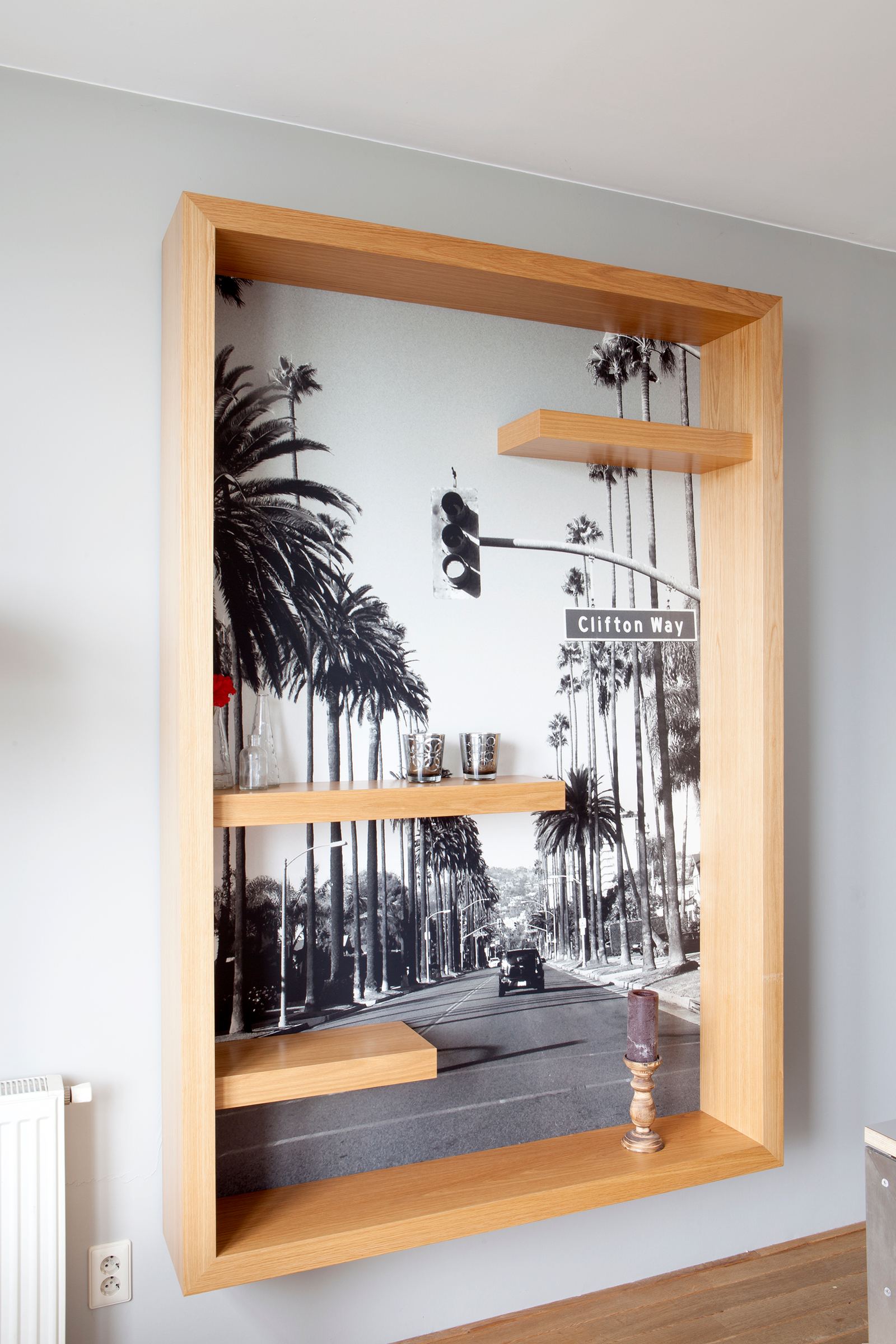 Diepe wandkast in eiken fineer met verspringende zwevende planken.