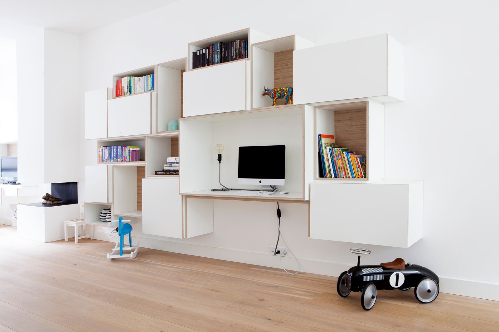 Asymmetrische wandkast van losse witte kastjes met berken binnenwerk.