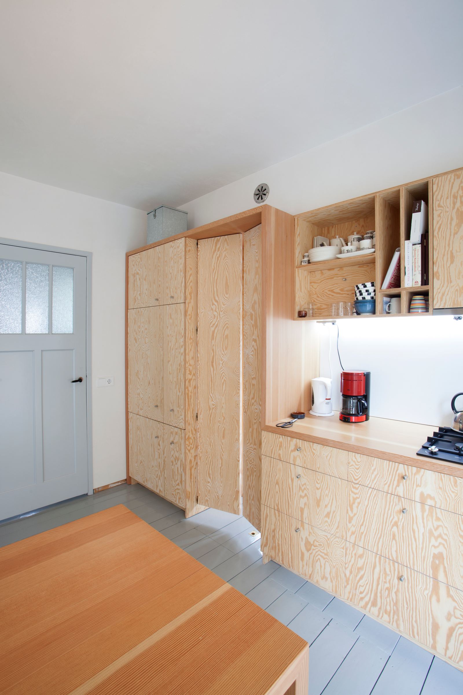 Houten keuken met gesloten kastenwand, een vouwdeur en een keukeneiland.