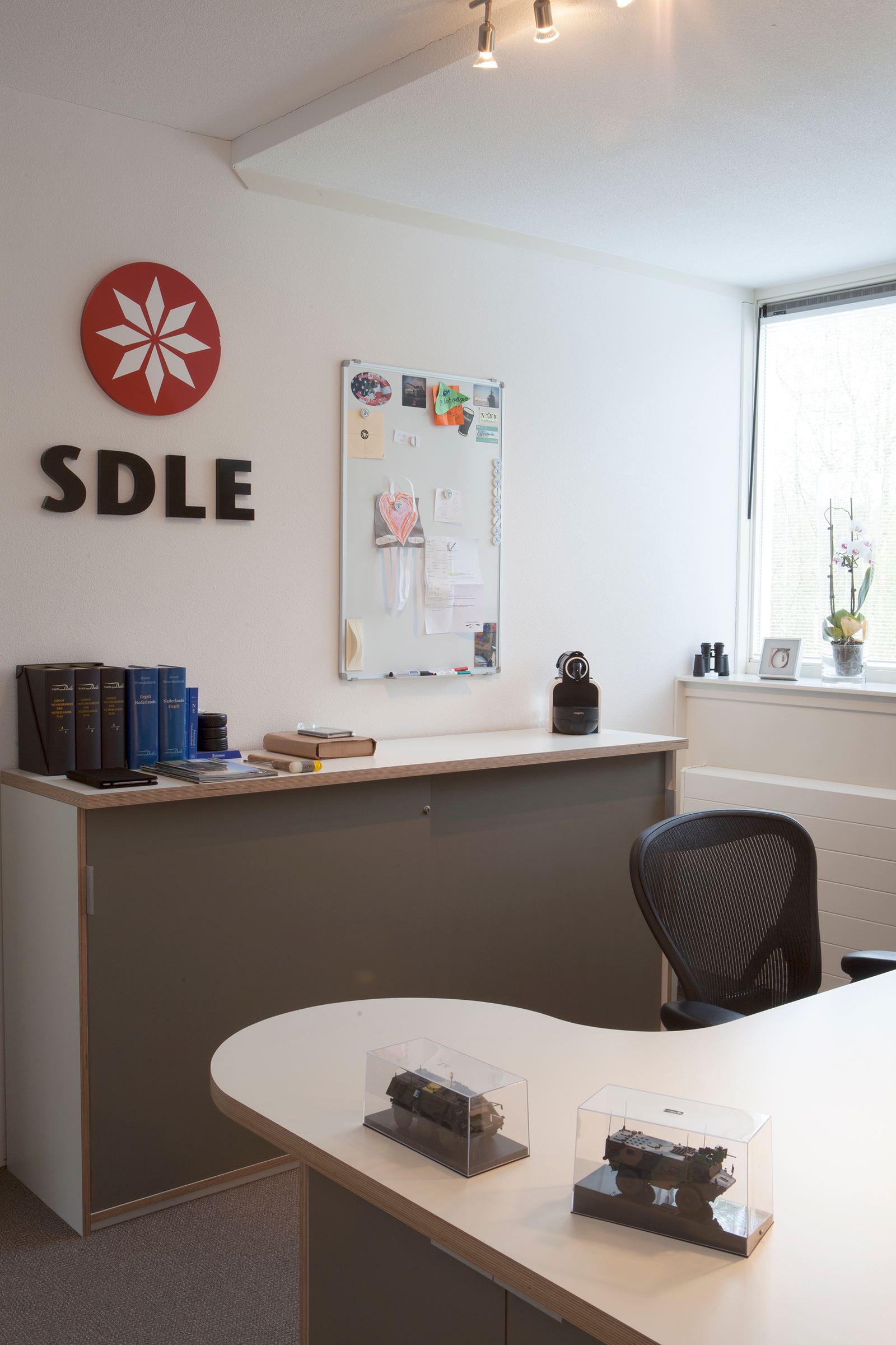 Kastenwand met een gesloten front, naast een bureau met plaatrand.